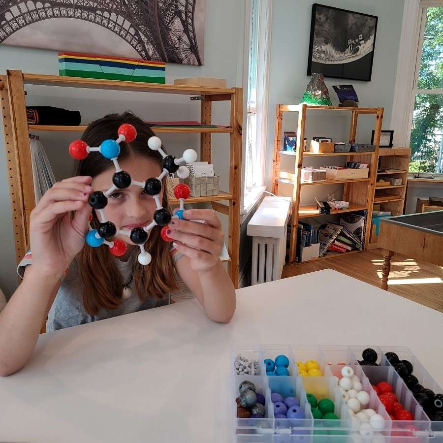 Lyonsgate Montessori Elementary student building a molecule model.
