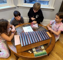 Montessori students learning a song on the xylophone.