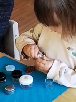 Montessori student working with Boxes and Bottles to develop fine motor skills.