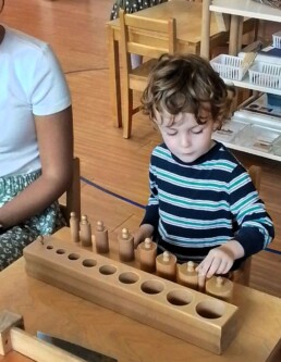 Montessori student working with the Montessori Cylinder Blocks material.