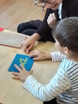 Montessori student working with the Sandpaper Letters material.