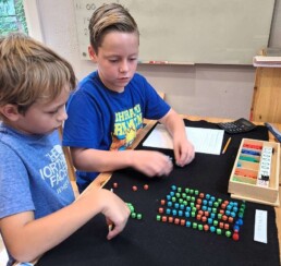Lyonsgate Montessori elementary students learning to divide decimal fractions.