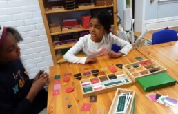 Lyonsgate Montessori Elementary students working with the Pronoun Grammar Box material.