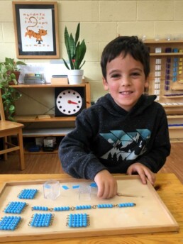 Lyonsgate Montessori student working with Bead Chain materials with an introduction to squaring.