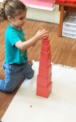 Lyonsgate Montessori student working with the Pink Tower material.