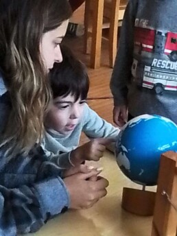 Lyonsgate Montessori student exploring the Sandpaper Globe with his Montessori guide.