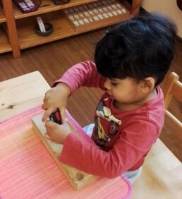 Lyonsgate Montessori student learning to use screwdriver and developing motor skills.