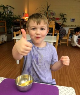 Lyonsgate Montessori student giving snack the thumbs up.