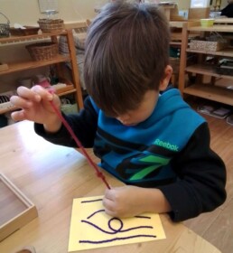 Lyonsgate Montessori student learning to tie a knot.