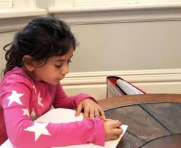 Lyonsgate Montessori Elementary third-year student writing in her journal at the circle table in the Oak Room.