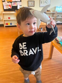 A new Lyonsgate Montessori Toddler student being brave, just like it says on his sweater.
