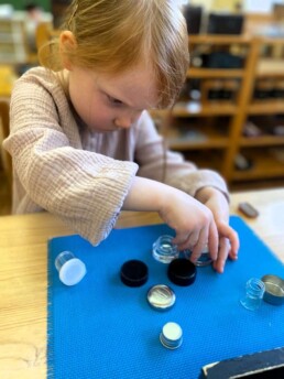 Lyonsgate Montessori Casa student working with the Boxes and Bottles material.