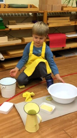 Lyonsgate Montessori student engaged in a cleaning activity.