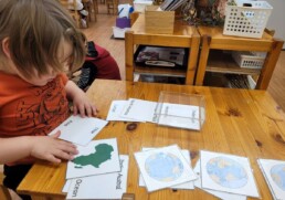 Lyonsgate Montessori student learning continent names in English and French.