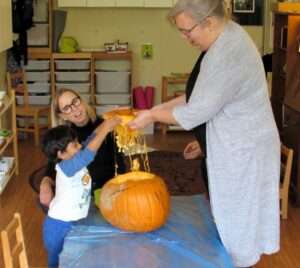 Lyonsgate Montessori Toddler student exploring a pumpkin, inside and out.