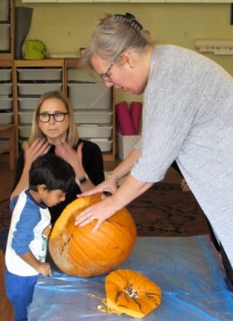Lyonsgate Montessori Toddler student exploring a pumpkin, inside and out.