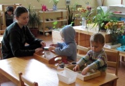 Lyonsgate Montessori Toddler students hard at work in their plant and flower-filled classroom.