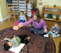 Lyonsgate Montessori Toddler students playing instruments, and laughing.