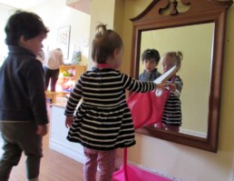 Lyonsgate Montessori Toddler student cleaning a mirror.