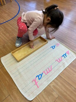 Lyonsgate Montessori student using the Moveable Alphabet material.