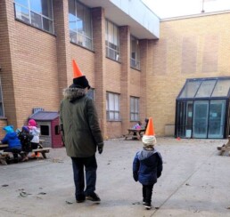 Walking the playground with pylons on their heads.