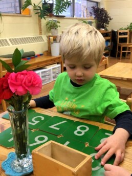 Lyonsgate Montessori Casa student learning numbers with the Sandpaper Numbers material.