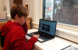 Lyonsgate Montessori Elementary student making a slideshow on a computer.