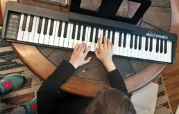 A fourth year student is playing a piano. And yes, we have added a keyboard to our classroom!