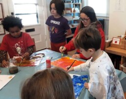 Lyonsgate Montessori Elementary students creating Eric Carle-style art.