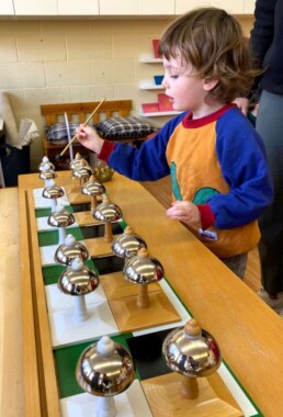 Lyonsgate Montessori Casa student using the Montessori Bells to develop auditory discrimination.