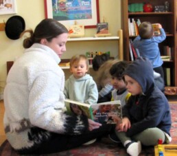 Lyonsgate Montessori Toddler students enjoying a book together.