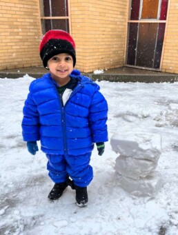 Lyonsgate Montessori Toddler student enjoying the brief appearance of snow.