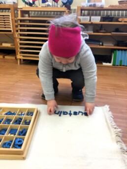 Lyonsgate Montessori Casa student working with the Montessori Moveable Alphabet.