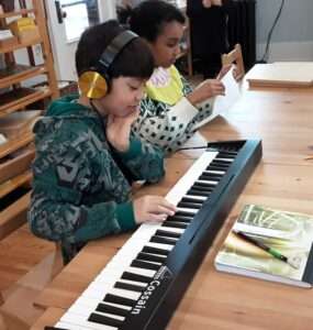 Lyonsgate Montessori Elementary student playing the classroom keyboard.