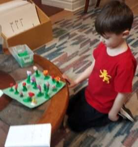 Lyonsgate Montessori Elementary student creating a garden out of plasticine.