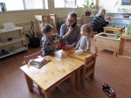 Lyonsgate Montessori Toddler students developing motor skills with a mailbox.