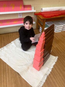 Lyonsgate Montessori Casa student extending the Montessori Pink Tower and Brown Stairs materials with Pattern Cards.