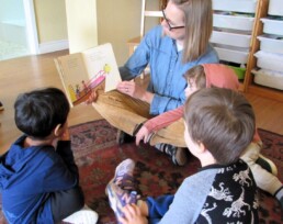Lyonsgate Montessori Toddler students reading with one of their teachers.