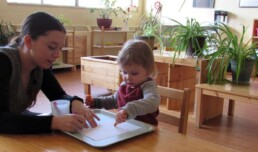 Lyonsgate Montessori Toddler student drawing with one of his teachers.