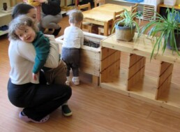 Lyonsgate Montessori Toddler student receiving a hug from one of his teachers.