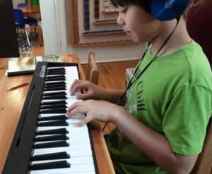 Lyonsgate Montessori Elementary student playing the keyboard.