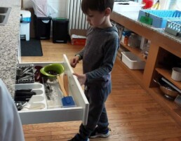 Lyonsgate Montessori Elementary student searching for just the right tool in the kitchen drawer.