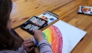 Lyonsgate Montessori Elementary student drawing a rainbow with pastels.