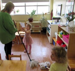 Lyonsgate Montessori Toddler students helping to clean the classroom and showing off artwork.