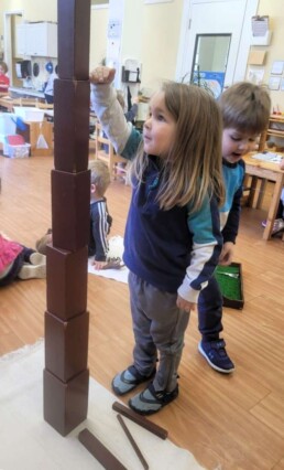 Lyonsgate Montessori Casa students checking the height of their tower.