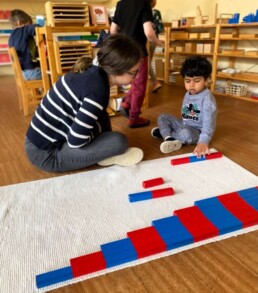 Lyonsgate Montessori Casa student working with the Montessori Number Rods material with his Montessori guide.