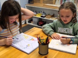 Lyonsgate Montessori School Elementary students drawing a house that contains the story of the universe and life.