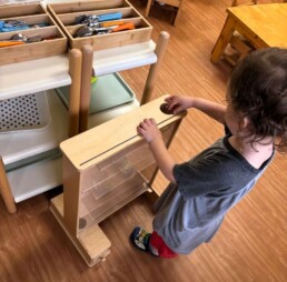 Lyonsgate Montessori School Toddler student developing hand-eye coordination with the ball tracker.