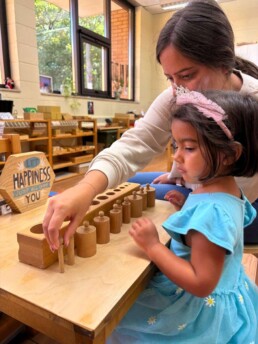 Lyonsgate Montessori School Casa student receiving a presentation with the Montessori Cylinder Blocks material.