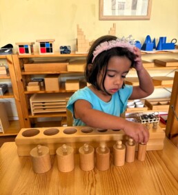 Lyonsgate Montessori School Casa student working with the Montessori Cylinder Blocks material.